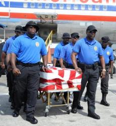 Officers receiving Officer Colvin George's remains (Photo courtesy of Government House). Officers receiving Officer Colvin George's remains (Photo courtesy of Government House).